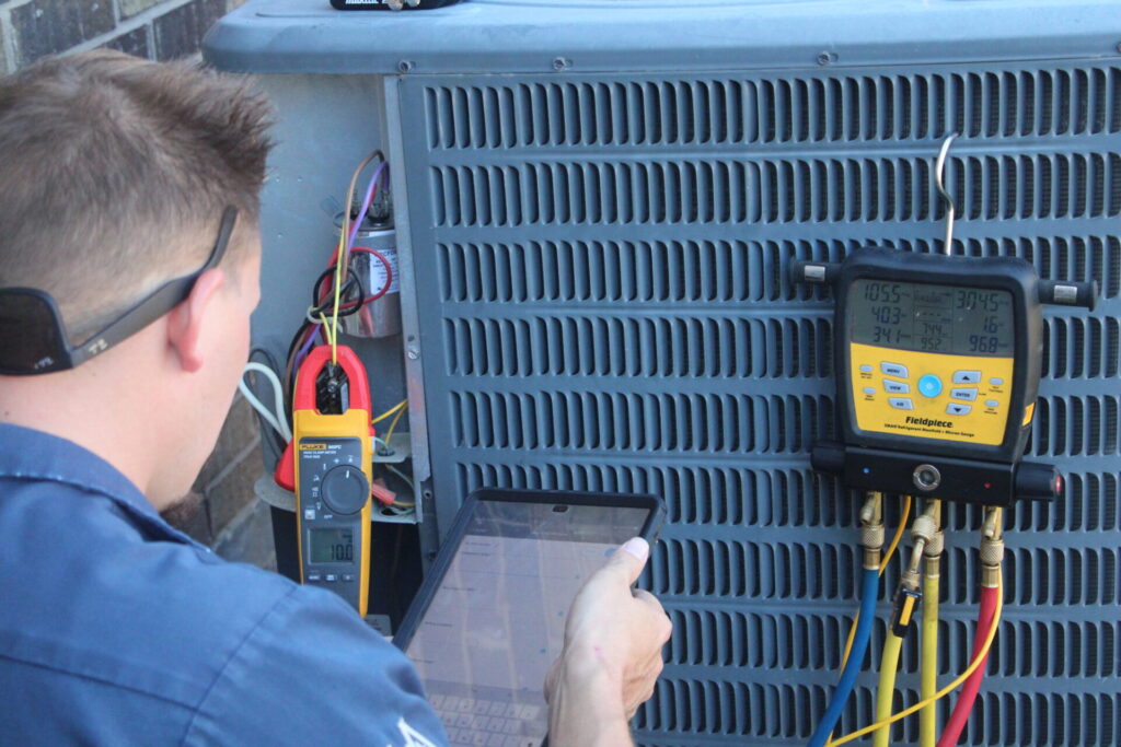 technician performing diagnostics on an outdoor unit