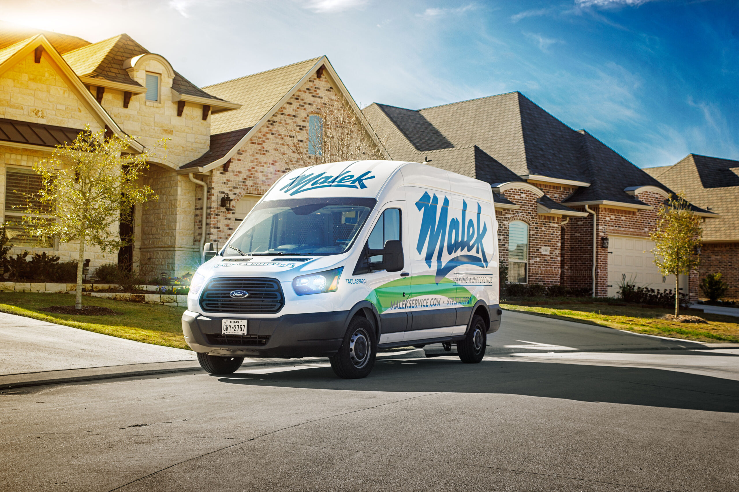 Malek Service Company van arriving in a Texas neighborhood