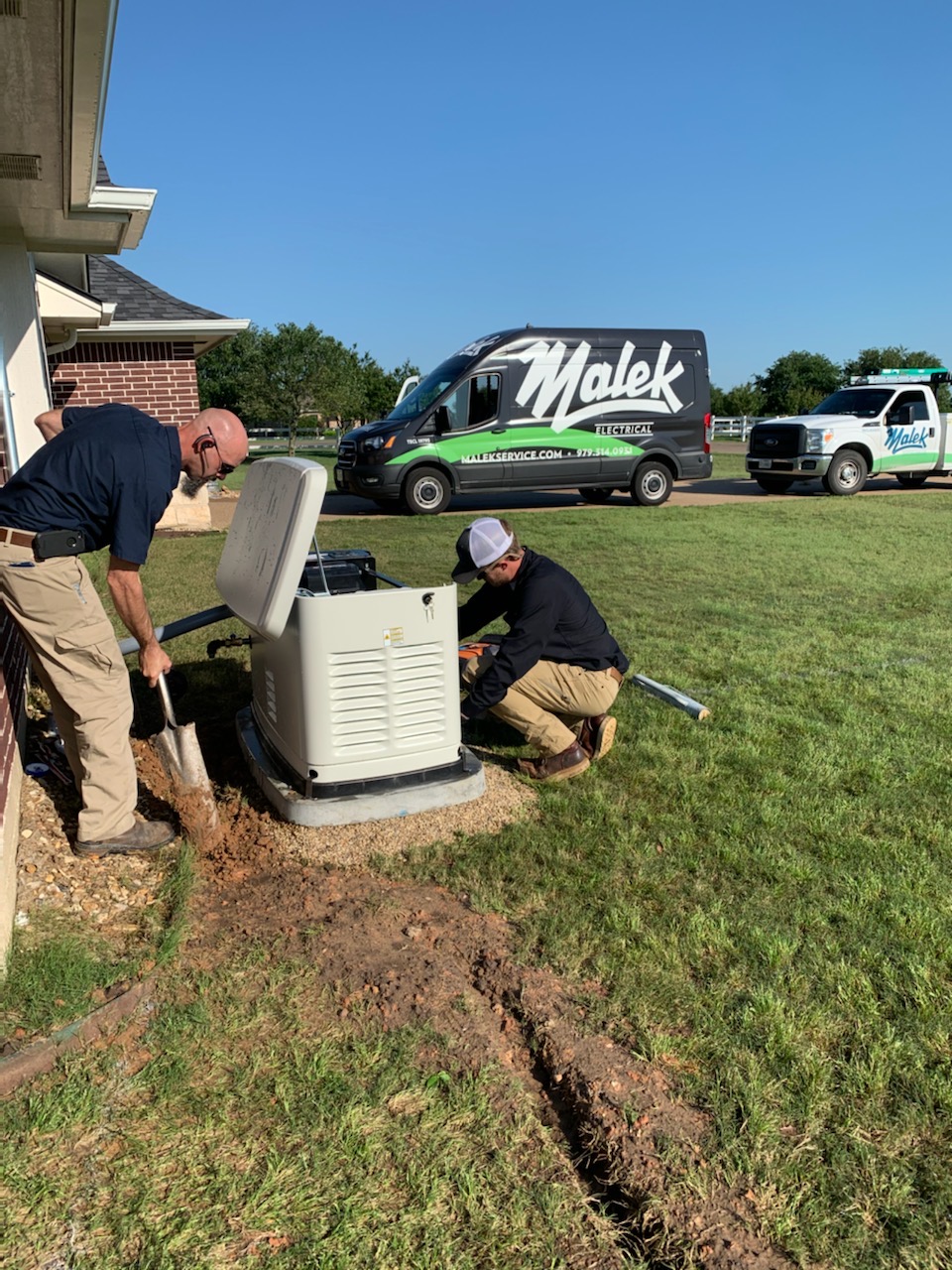 Malek technicians working on a residential whole-home generator