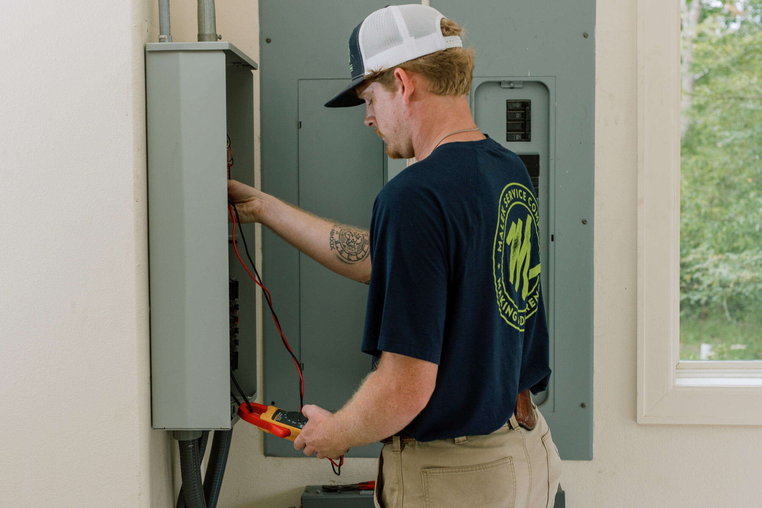 Malek electrical professional helping a homeowner understand their electrical system.