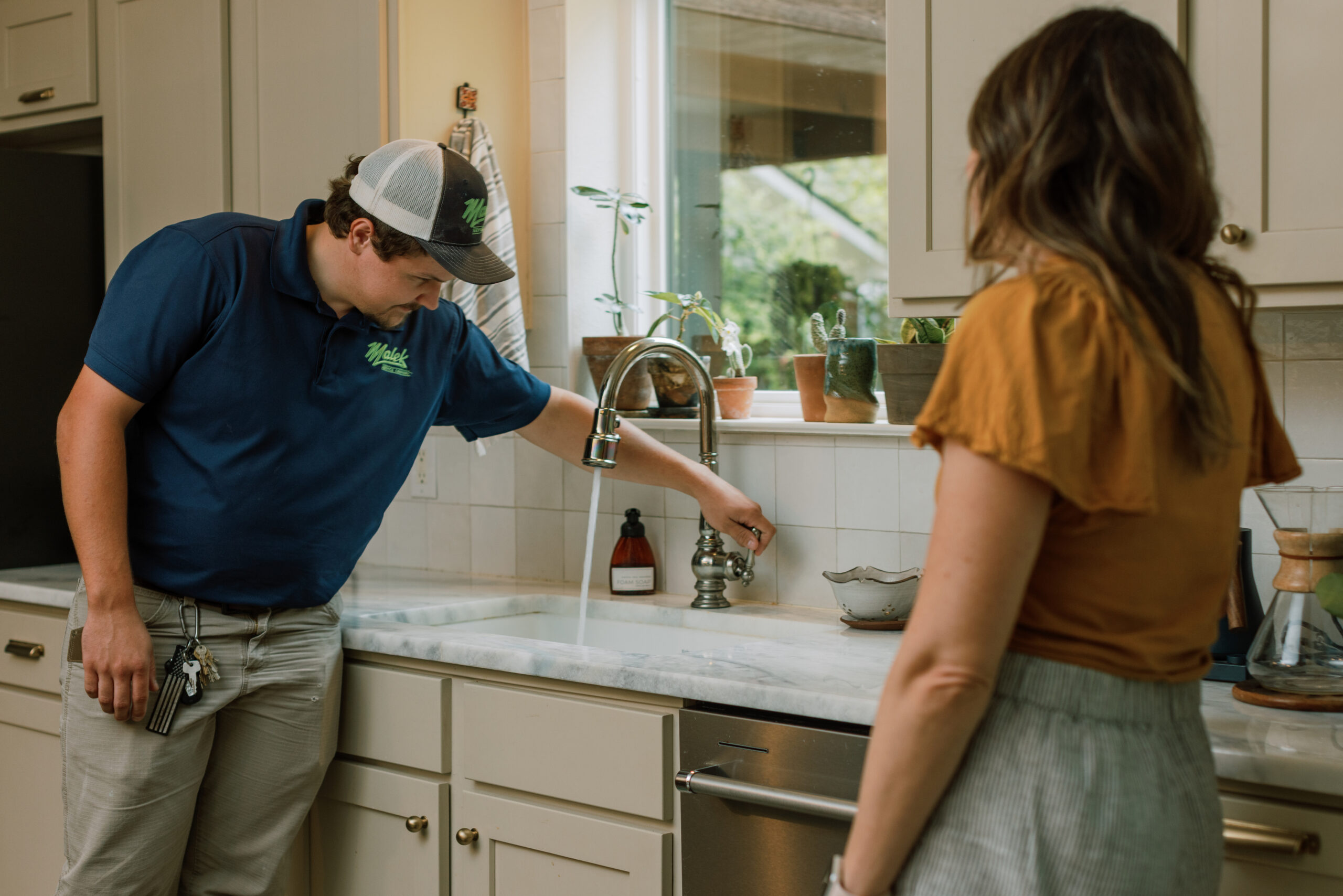 Malek plumbing professional inspecting a home's plumbing system.