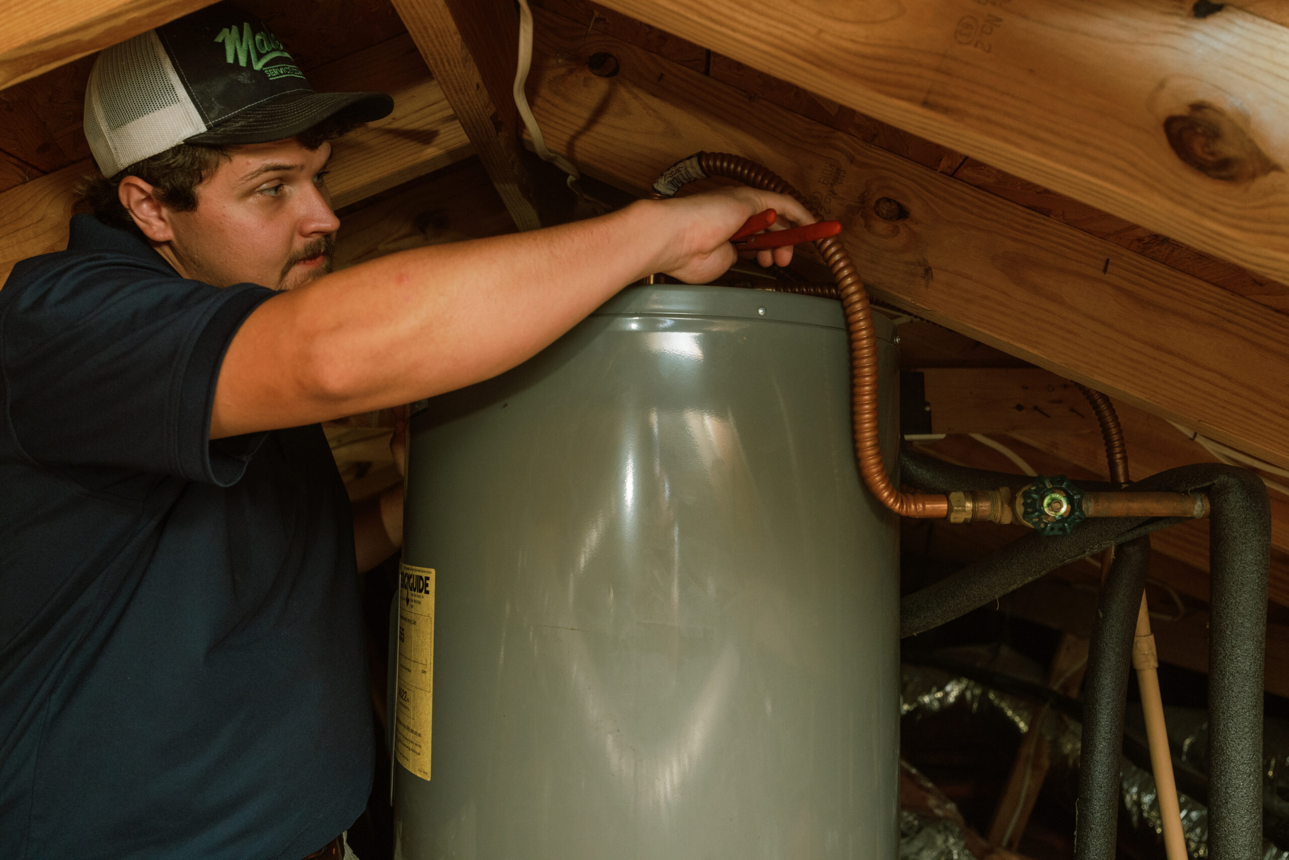 Malek plumber inspecting and repairing a residential water heater