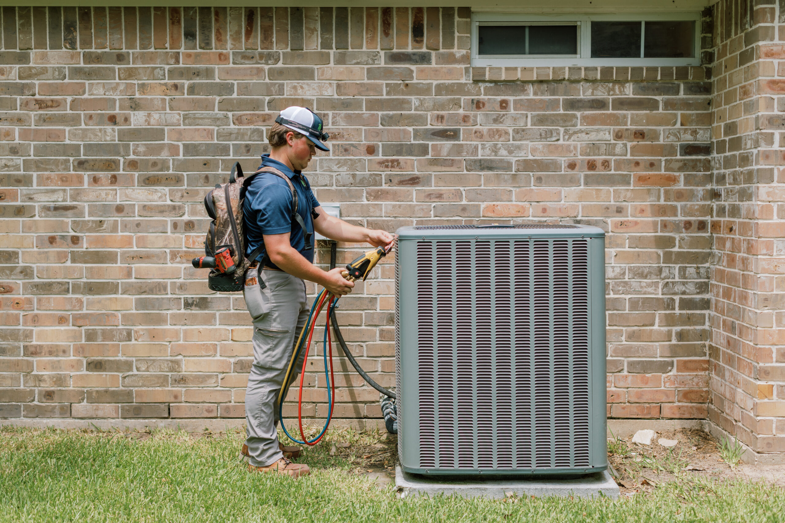 Malek HVAC technician servicing an outdoor air conditioning system