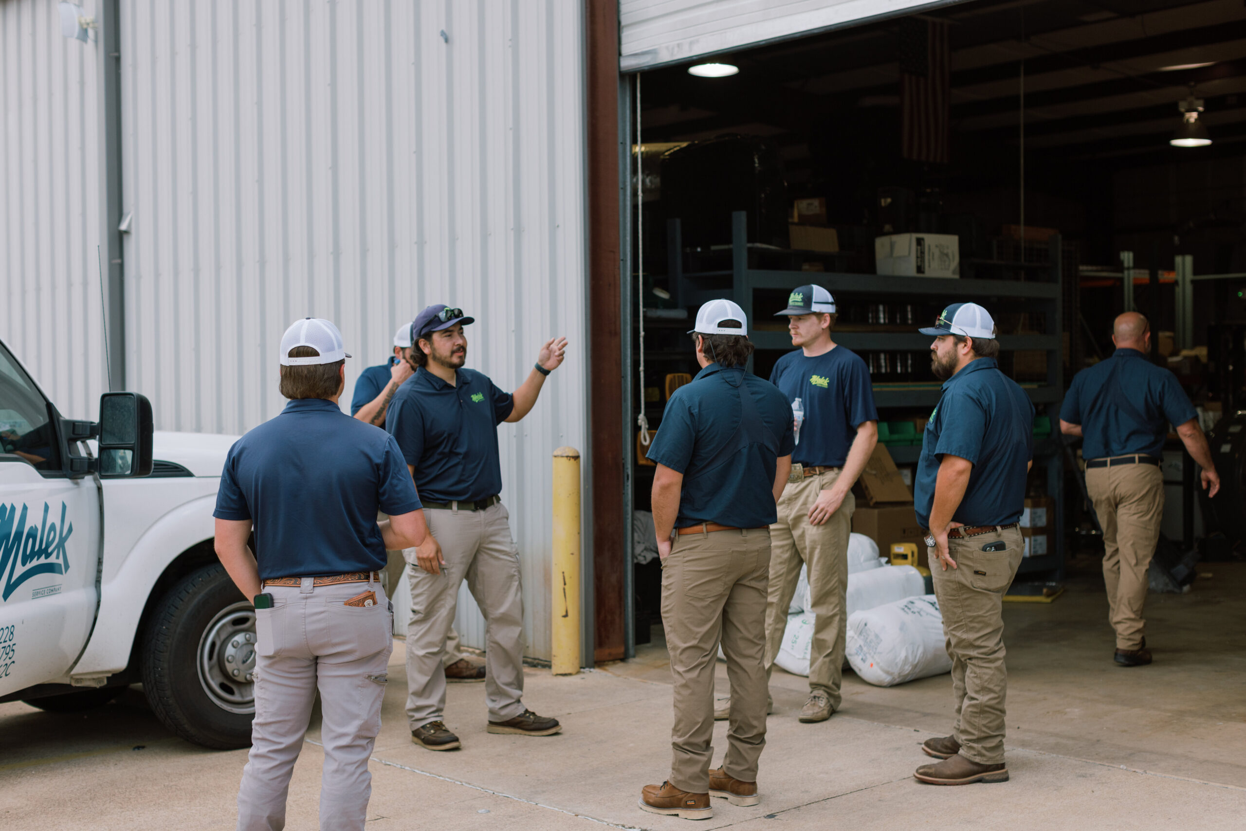 Malek team members gathered in the company warehouse