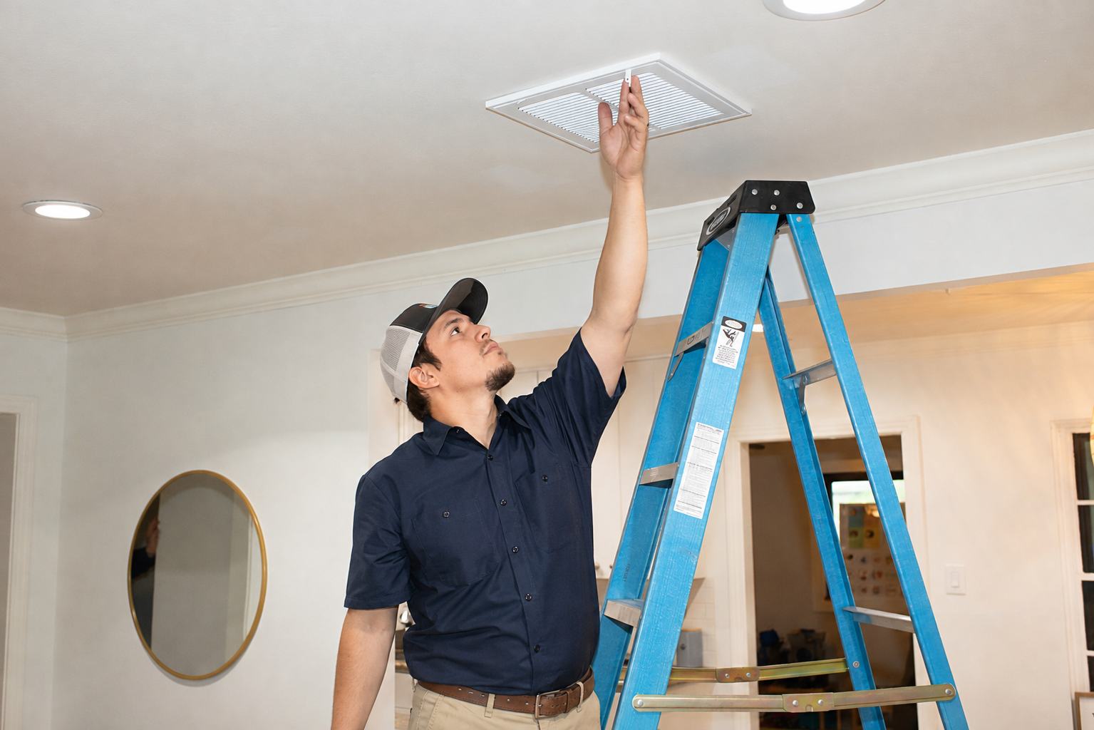 Technician performing residential air duct cleaning