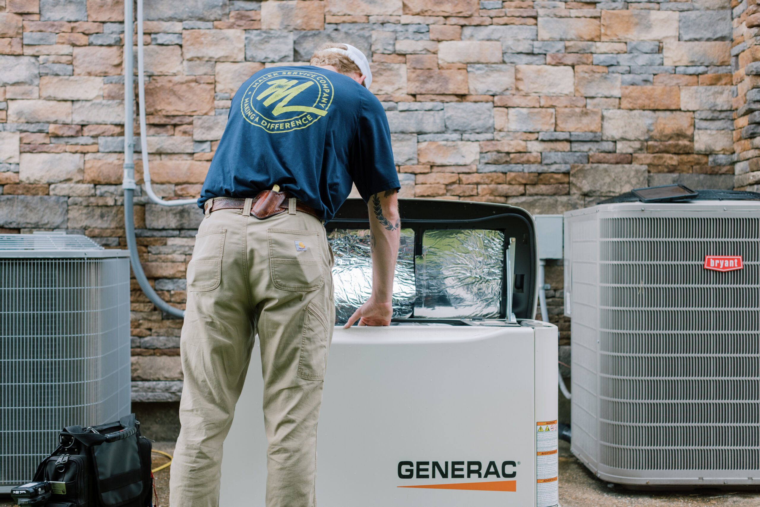 Malek technician servicing a residential whole-home standby generator