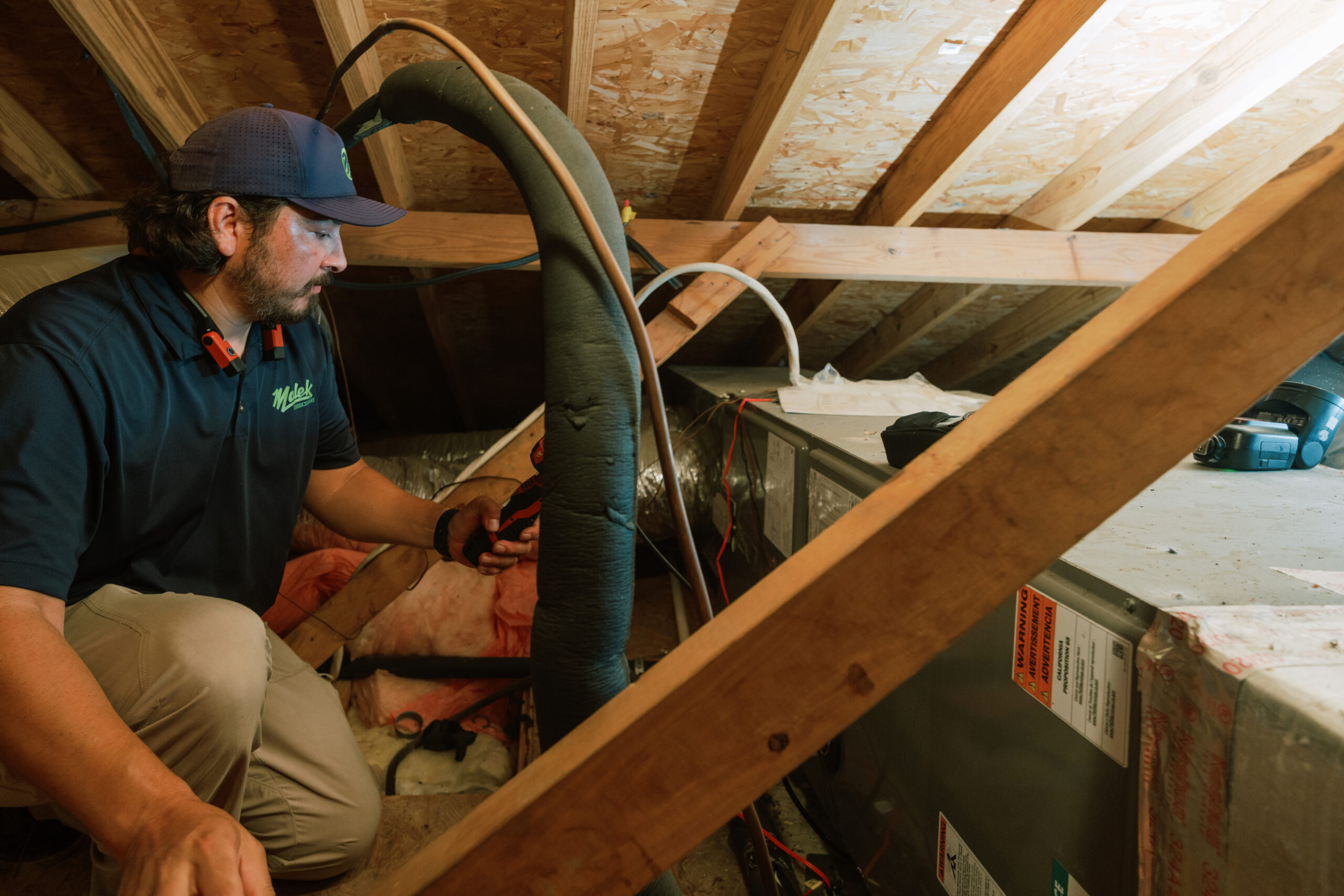 Malek HVAC technician performing residential heating system maintenance